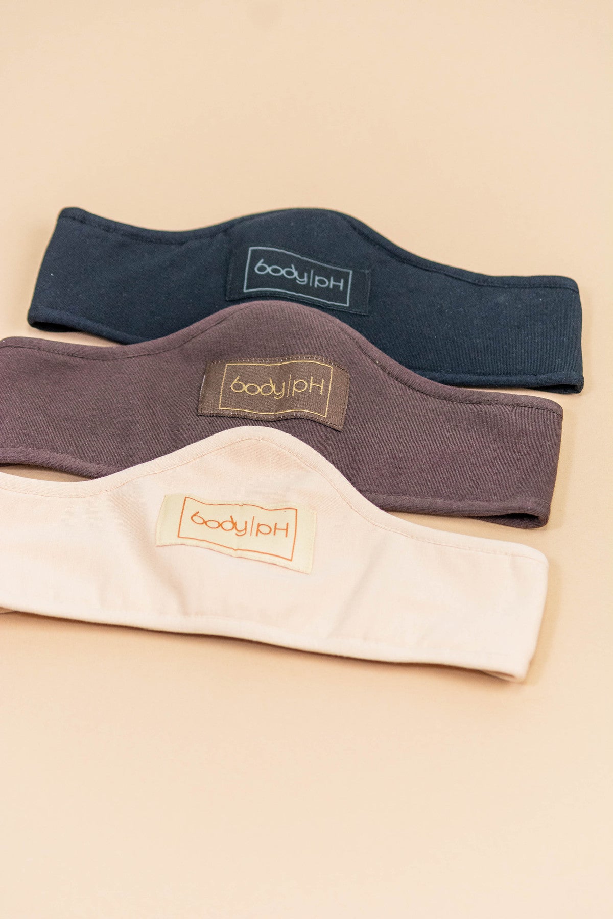 Three body pH bra liners in three colours on a beige background in three colours: beige, brown and black.