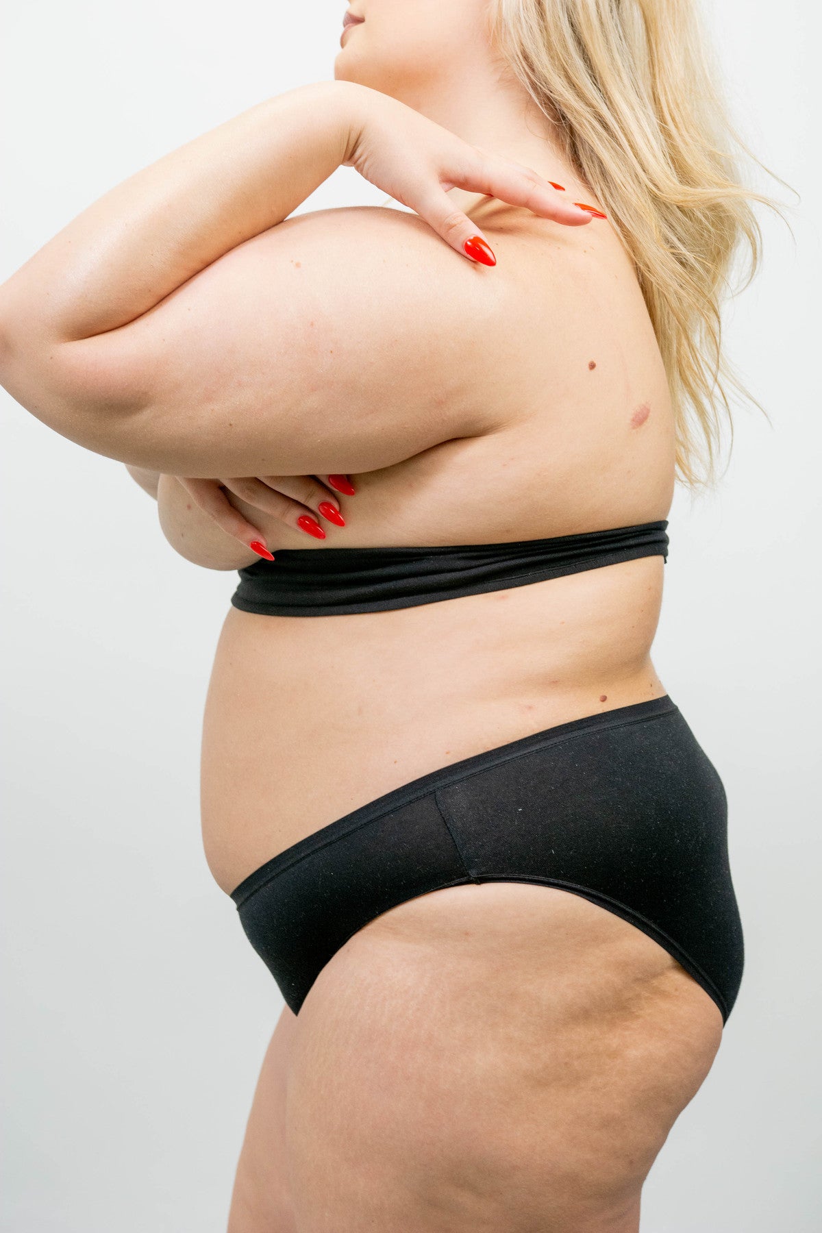 Shown from the side, the body pH bra liner is worn under the breasts and fastens at the back.